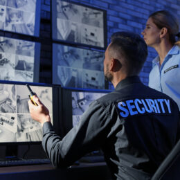 Security guards monitoring modern CCTV cameras indoors